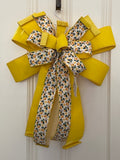 Large decorative bow for wreaths or door hangers comprised of a 4" Farrisilk lemon yellow velvet ribbon and a 2.5" Farrisilk white with lemons ribbon on a neutral background