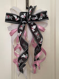 Large decorative bow for wreaths or door hangers comprised of a 4" Farrisilk white w/ black dots ribbon, a 2" black and white bunnies ribbon, a 1" light pink satin ribbon, and a 1" white flocked ribbon on a neutral background