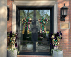 2 pairs of matching decorative bows with 1 pair hung from glass front doors and the other pair hung from a trellis in large grey planters